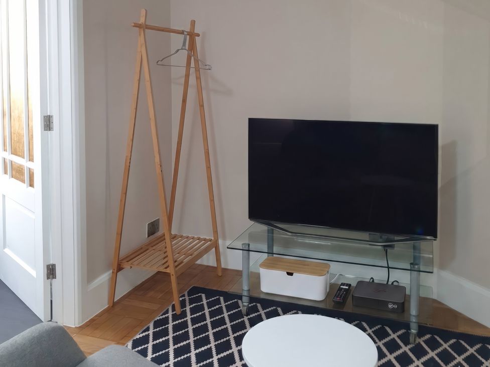 A living room featuring a television and a hanging rack at Kinamara Ensuite Room Margate