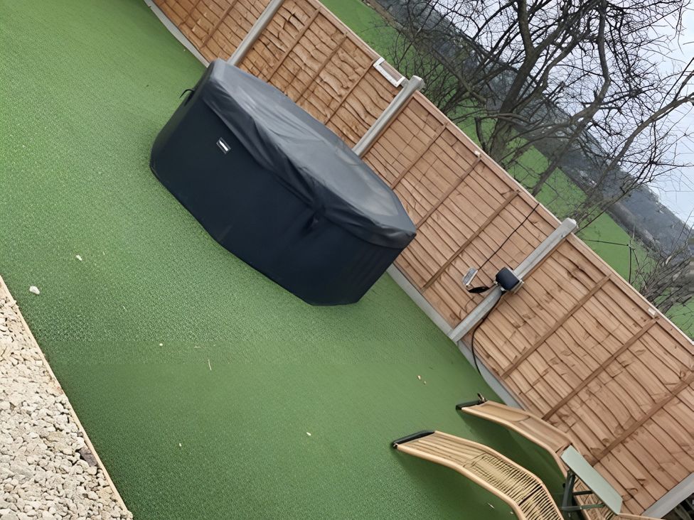 An outdoor area with a hot tub and lawn chair at Cotswold Nights Away Evesham