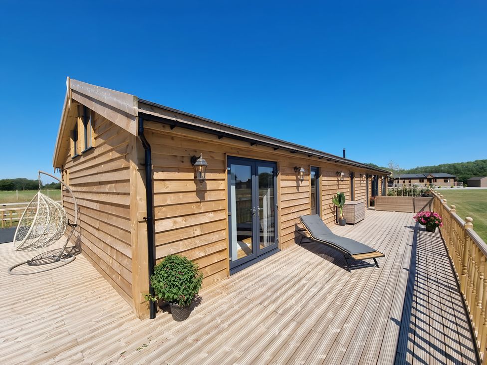 An outdoor area with a wooden cabin and seating at Fox Lodge in York