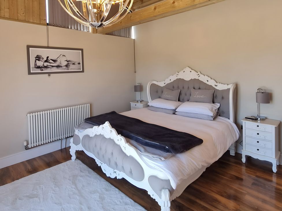 A bedroom with a bed and nightstands at Fox Lodge York