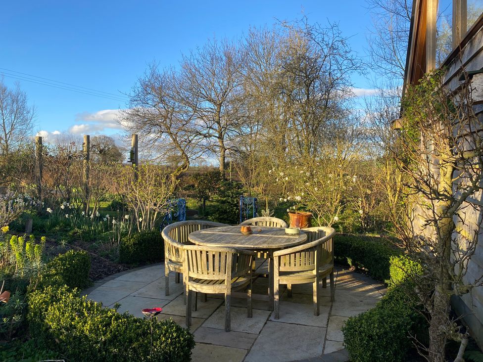A garden with a round table and chairs at Christmas Cottage in Shipston-on-Stour
