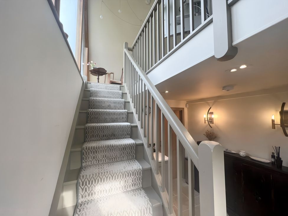 A staircase with a railing and light fixtures at Christmas Cottage in Shipston-on-Stour