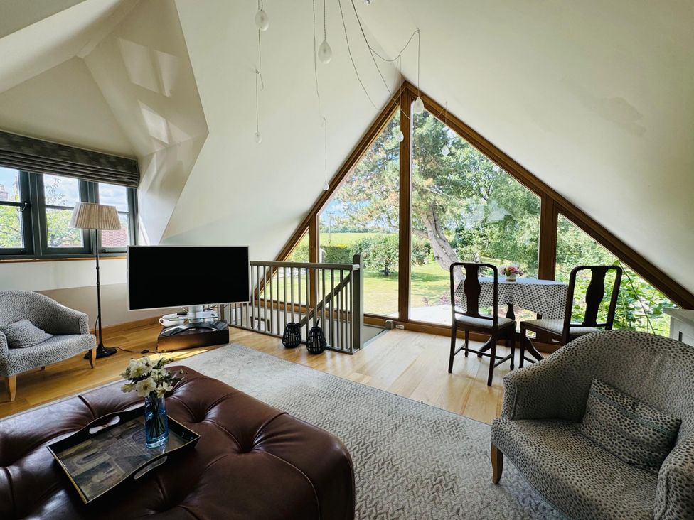 A living room with a television and seating area at Christmas Cottage in Shipston-on-Stour