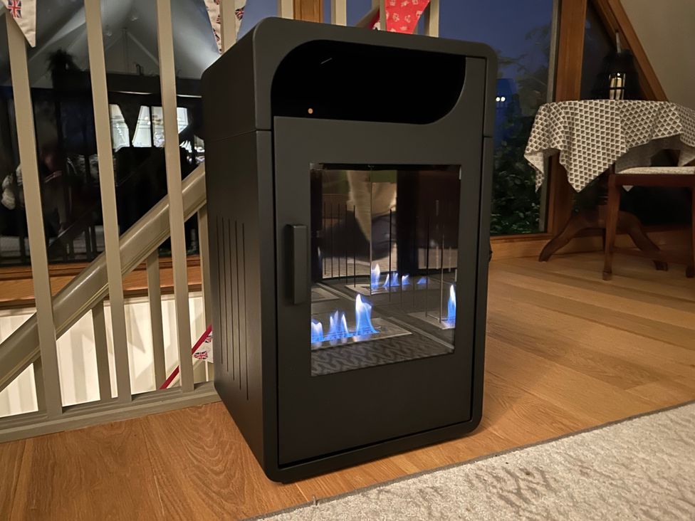 A fireplace with flames in a living room at Christmas Cottage in Shipston-on-Stour