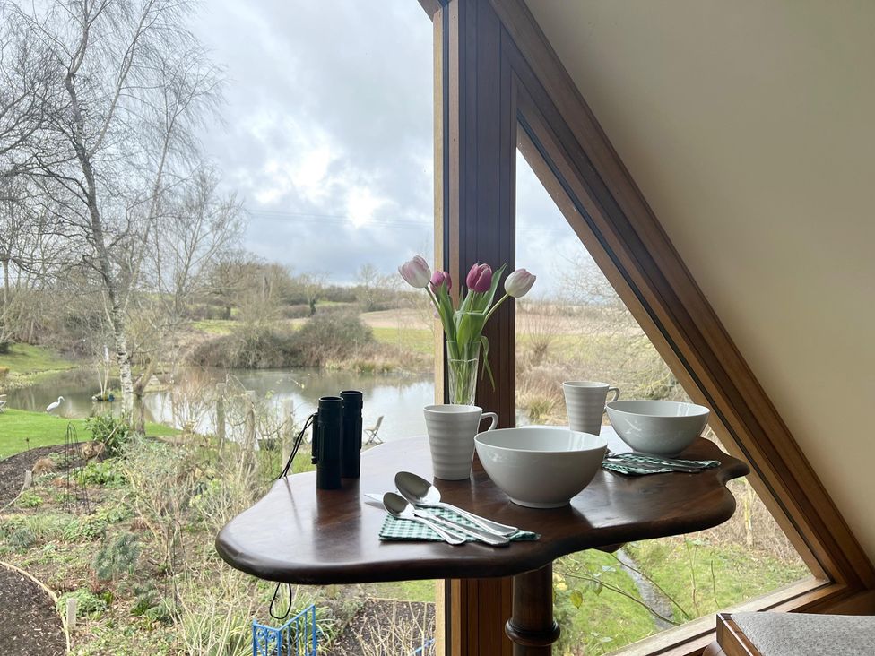 A dining table with tulips and bowls at Christmas Cottage Shipston-on-Stour