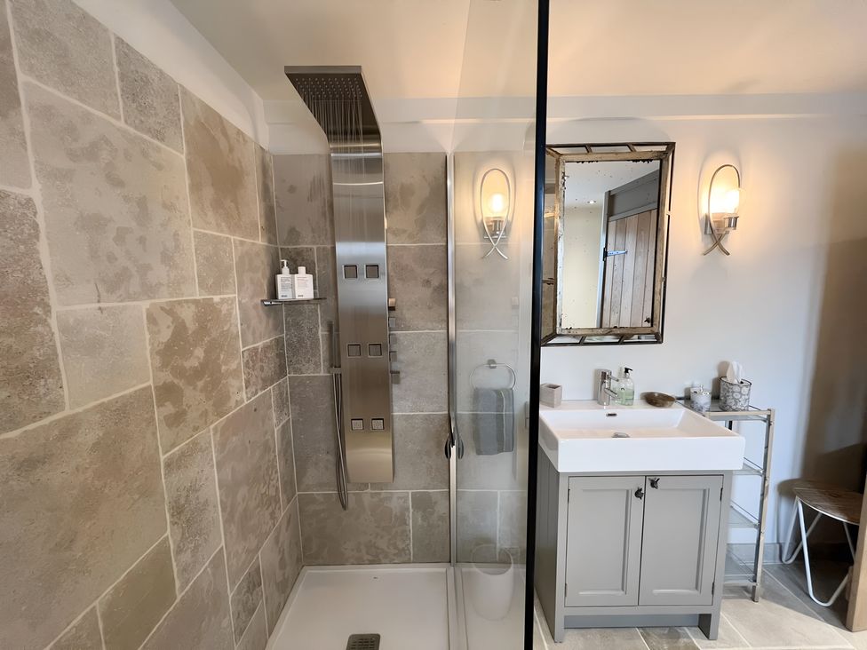 A bathroom featuring a shower, sink, and mirror at Christmas Cottage in Shipston-on-Stour