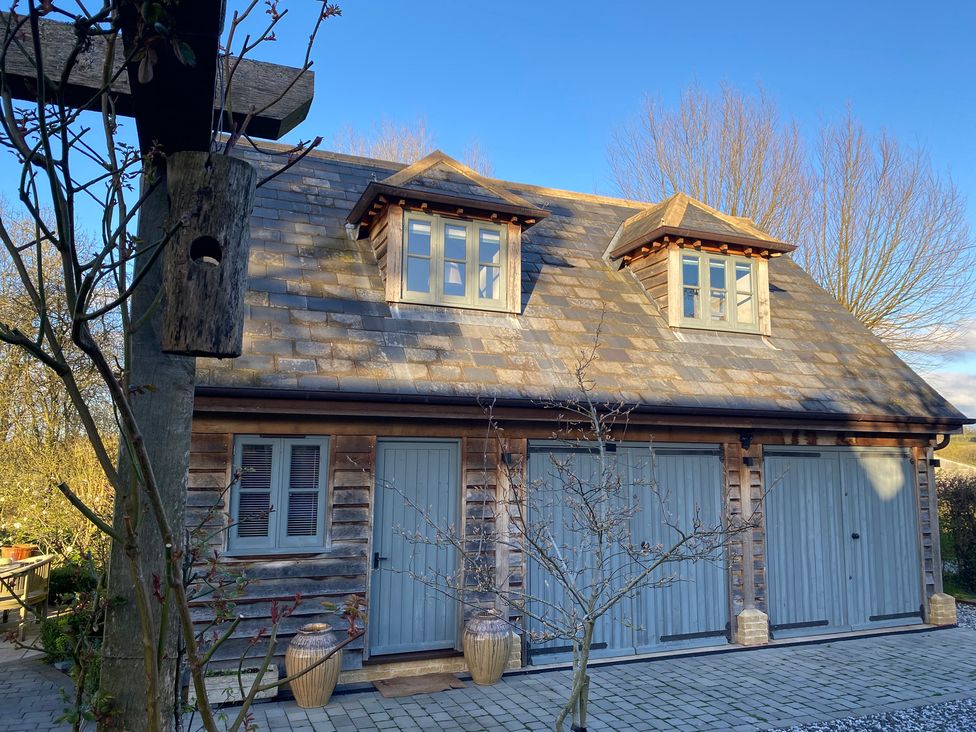 A building with garage doors and windows at Christmas Cottage in Shipston-on-Stour