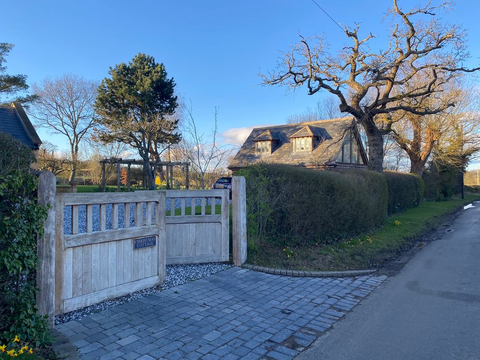 A house with a wooden gate and trees at Christmas Cottage in Shipston-on-Stour