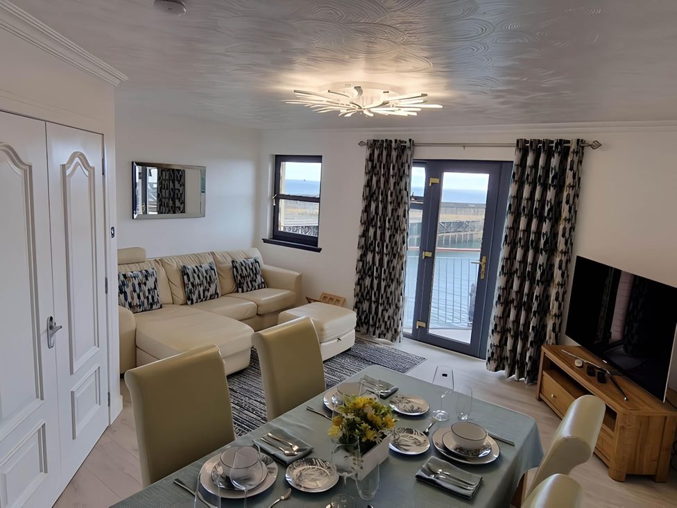 A living room with a sofa and dining table at 36 Deas Wharf in Kirkcaldy