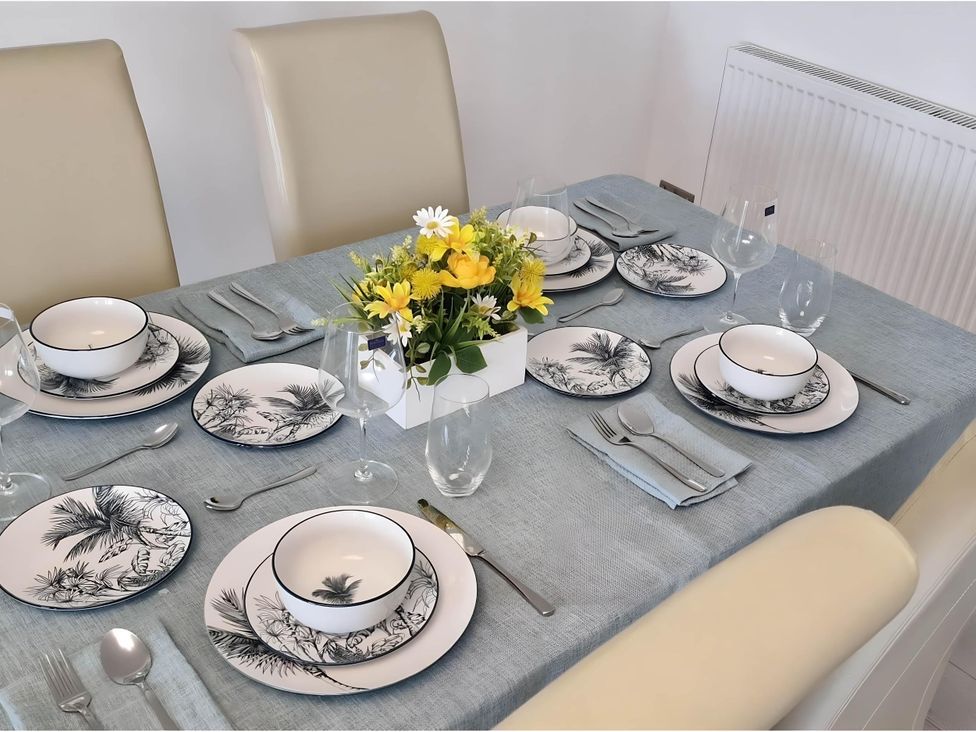 A dining table set with plates and flowers at 36 Deas Wharf in Kirkcaldy