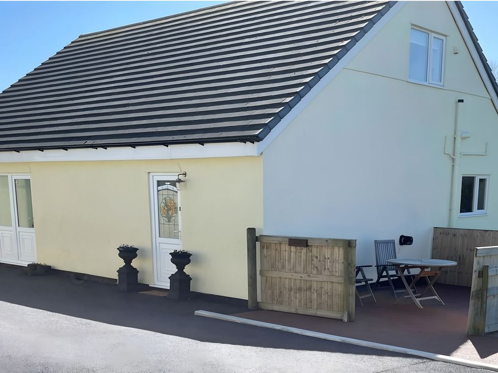A house with a door, window, table, and chairs at Country Retreat Sleeps 2 in Holyhead