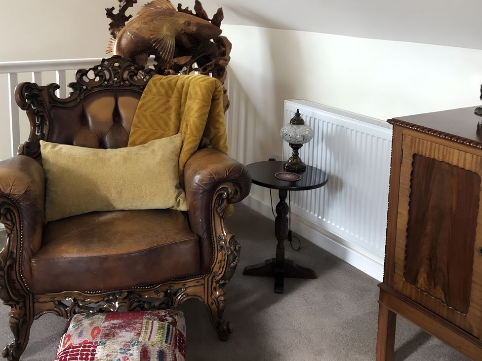 A snug area with an armchair and side table at Country Retreat Sleeps 2 Holyhead