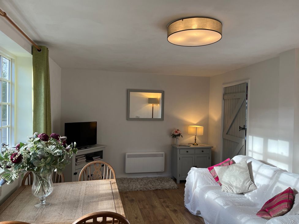 A living room with a dining table and a television at Loxley Barn in Tring