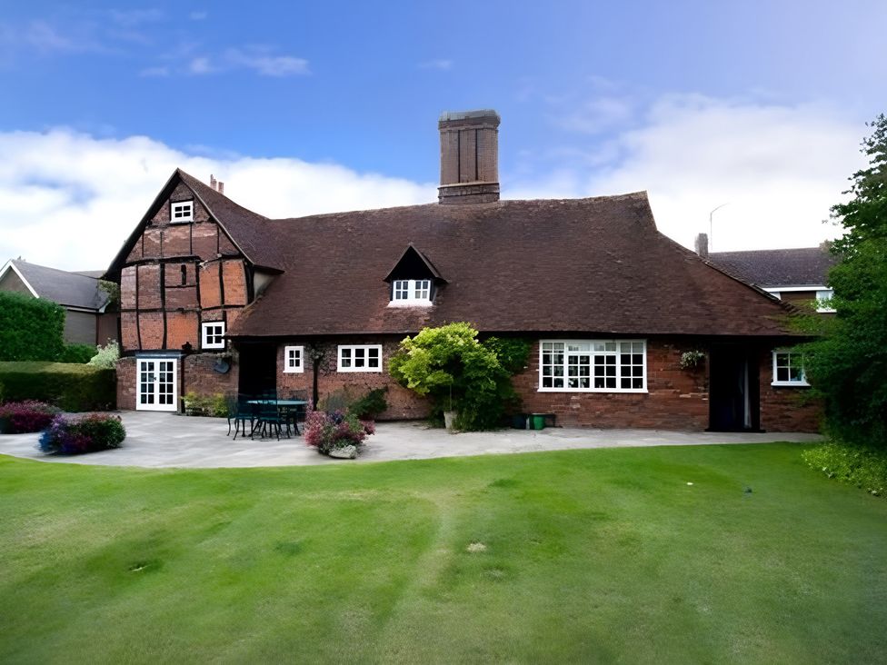 A house with a garden and patio furniture at Loxley Barn in Tring
