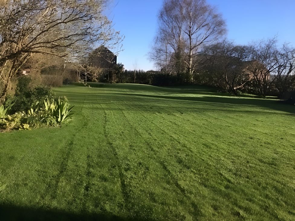 A garden with grass and trees at Loxley Barn in Tring