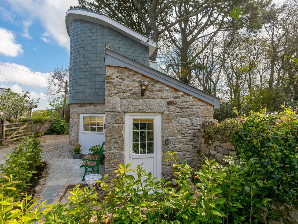 An outdoor view of a stone building with a pathway and plants at The Old Well House in Redruth