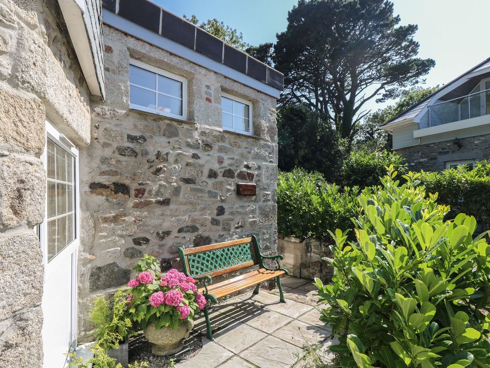 An outdoor area with a bench and flower pot at The Old Well House in Redruth