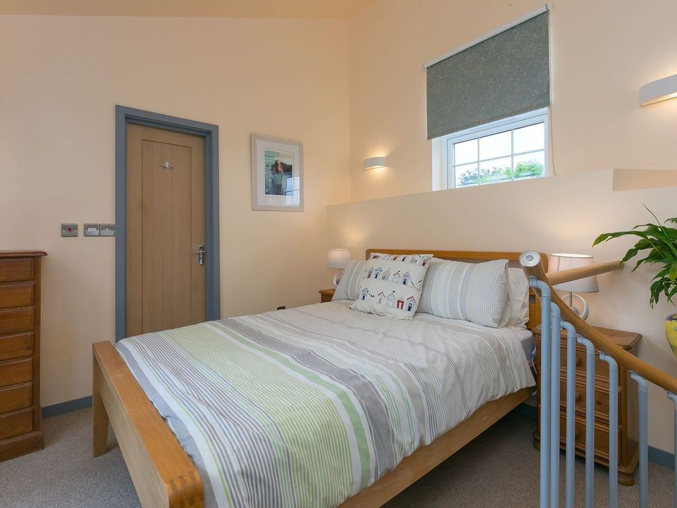 A bedroom with a bed and bedside tables at The Old Well House in Redruth