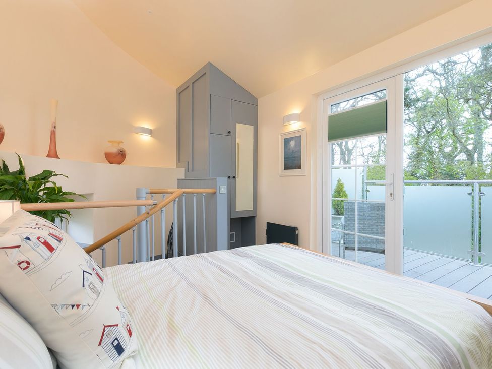 A bedroom with a bed and wardrobe at The Old Well House in Redruth