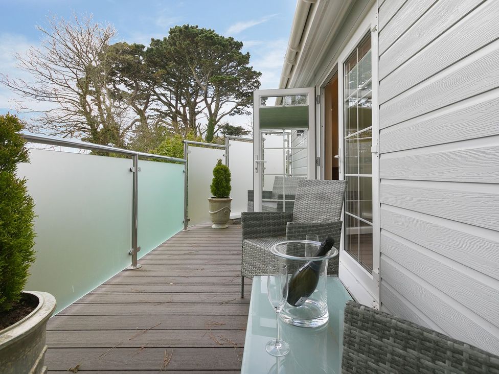 A balcony with chairs and a table at The Old Well House in Redruth