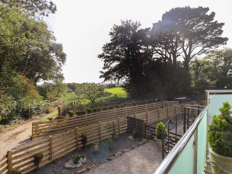 A garden with trees and a fence at The Old Well House in Redruth