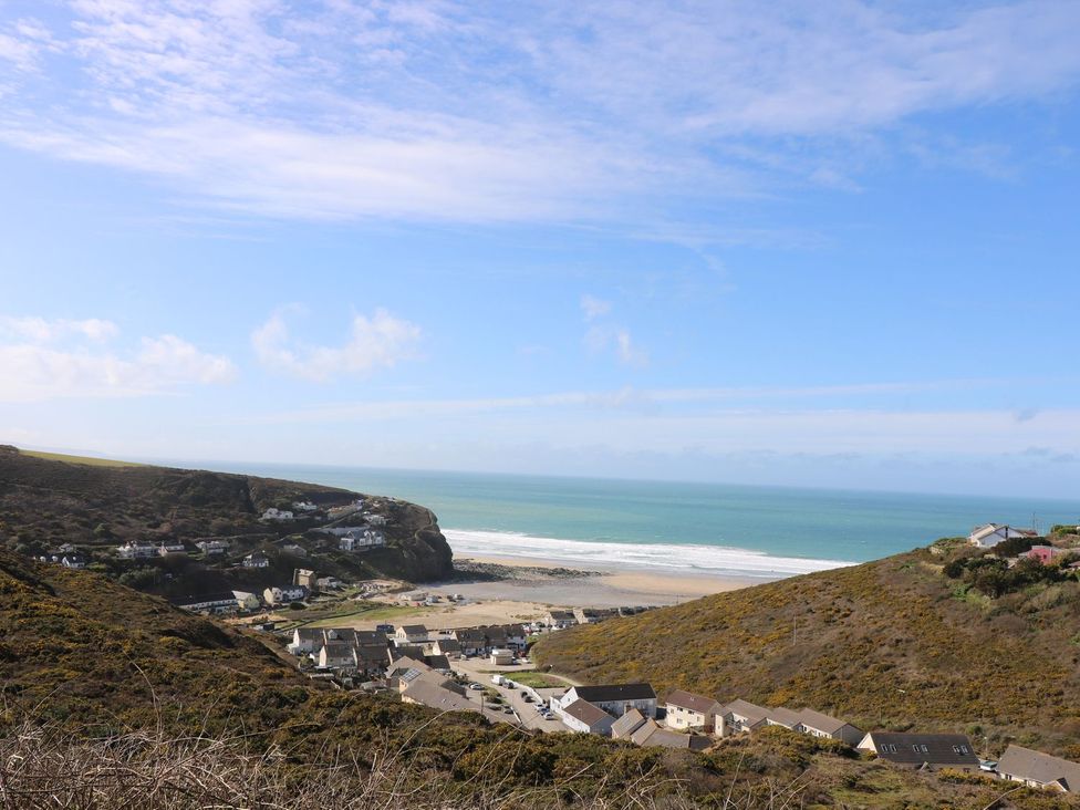 A coastal view of houses and beach at The Old Well House in Redruth