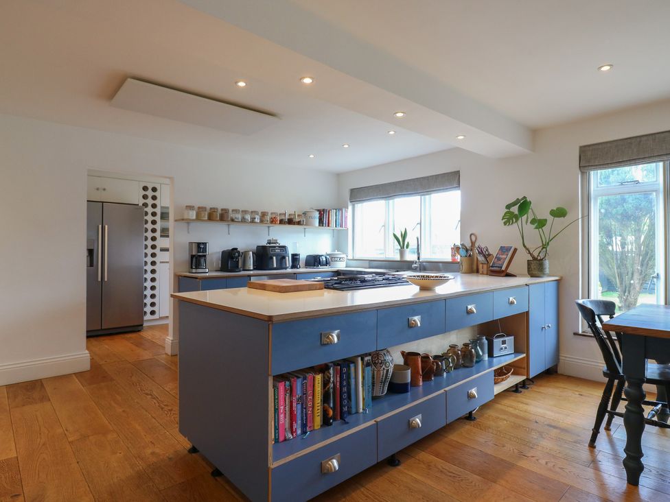 A kitchen with a fridge, oven, and dining table at Denmark House, Chatham, Kent