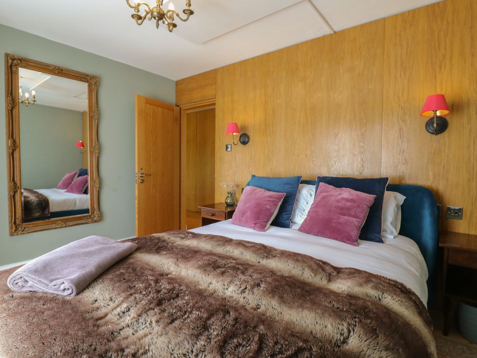 A bedroom with a bed, pillows, and a mirror at Denmark House in Chatham, Kent