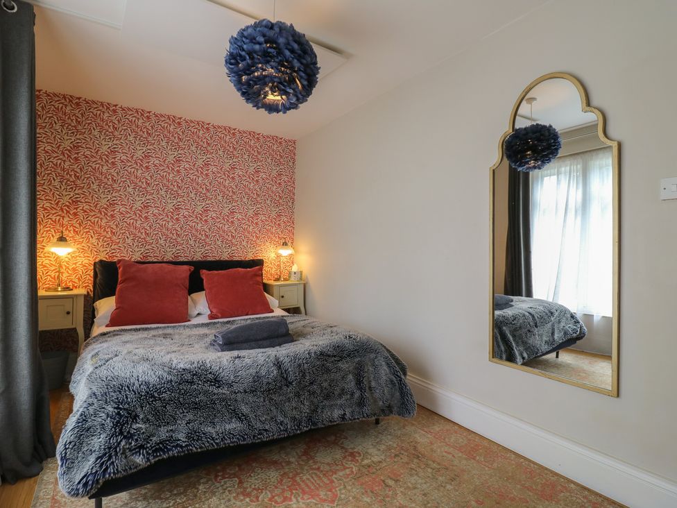 A bedroom with a bed and mirror at Denmark House in Chatham, Kent