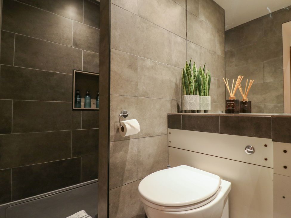 A bathroom with a toilet and shelf at Denmark House in Chatham, Kent