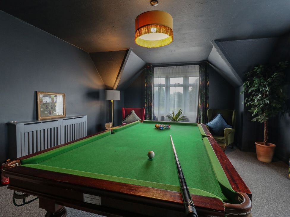 A game room with a pool table and seating at Denmark House in Chatham, Kent