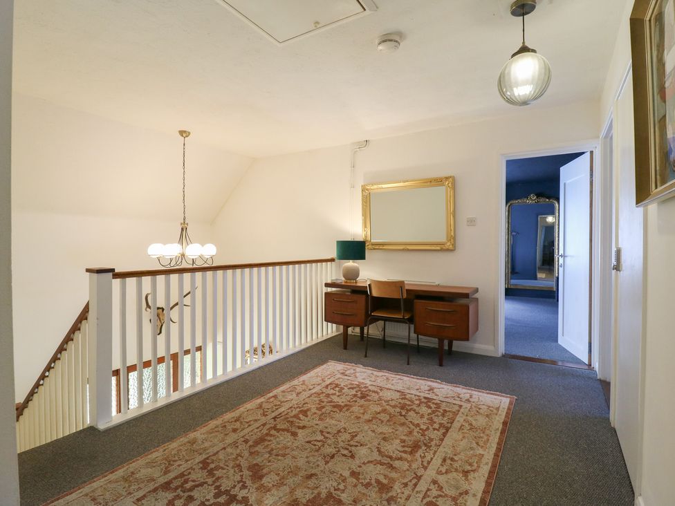 A hallway with a console table and light fixture at Denmark House in Chatham, Kent