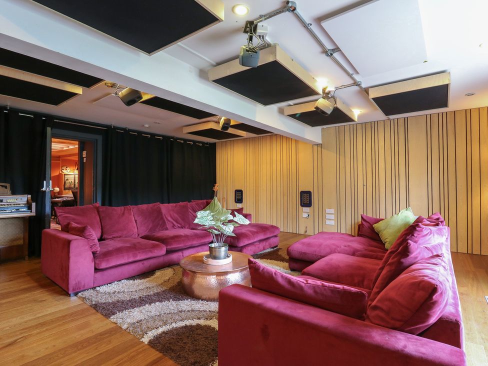 A snug with a large sofa and acoustic panels at Denmark House in Chatham, Kent