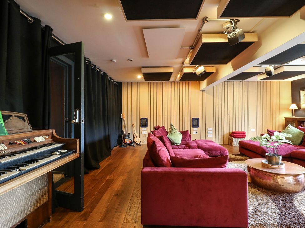A snug with an organ, sofas, and potted plants at Denmark House in Chatham, Kent