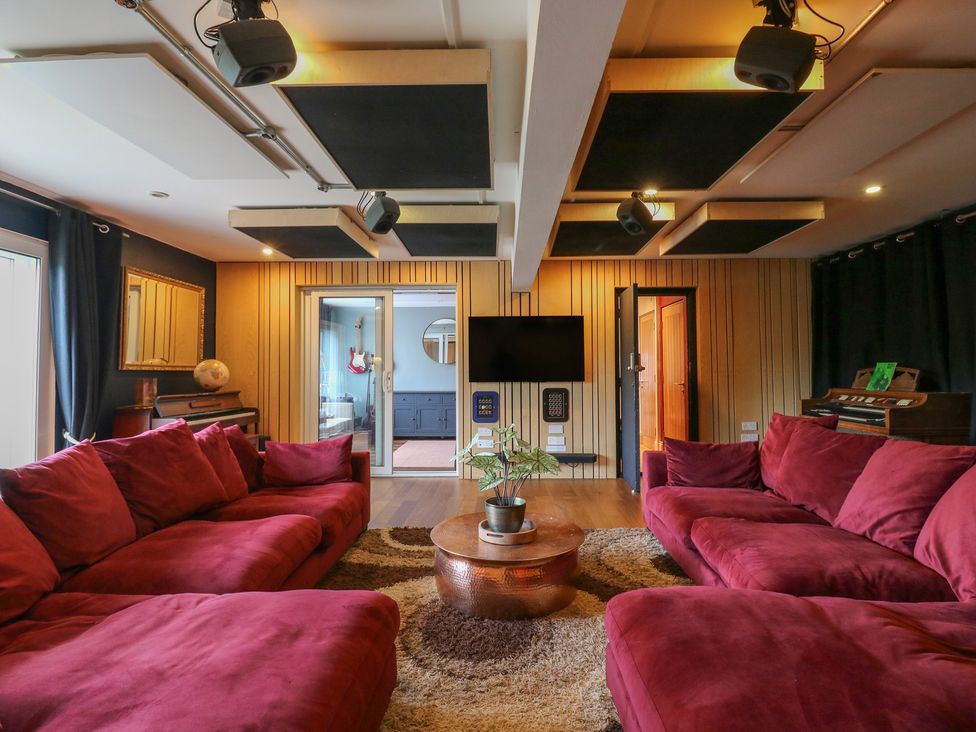 A living room with red sofas and a television at Denmark House in Chatham, Kent