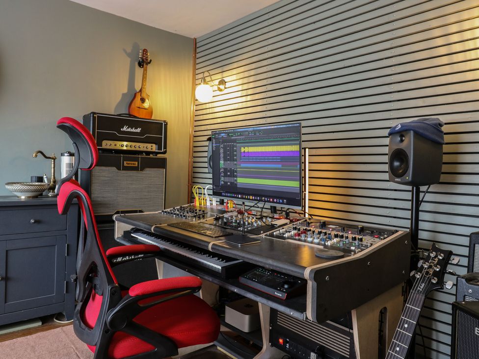 A music studio with an audio mixer and instruments at Denmark House in Chatham, Kent
