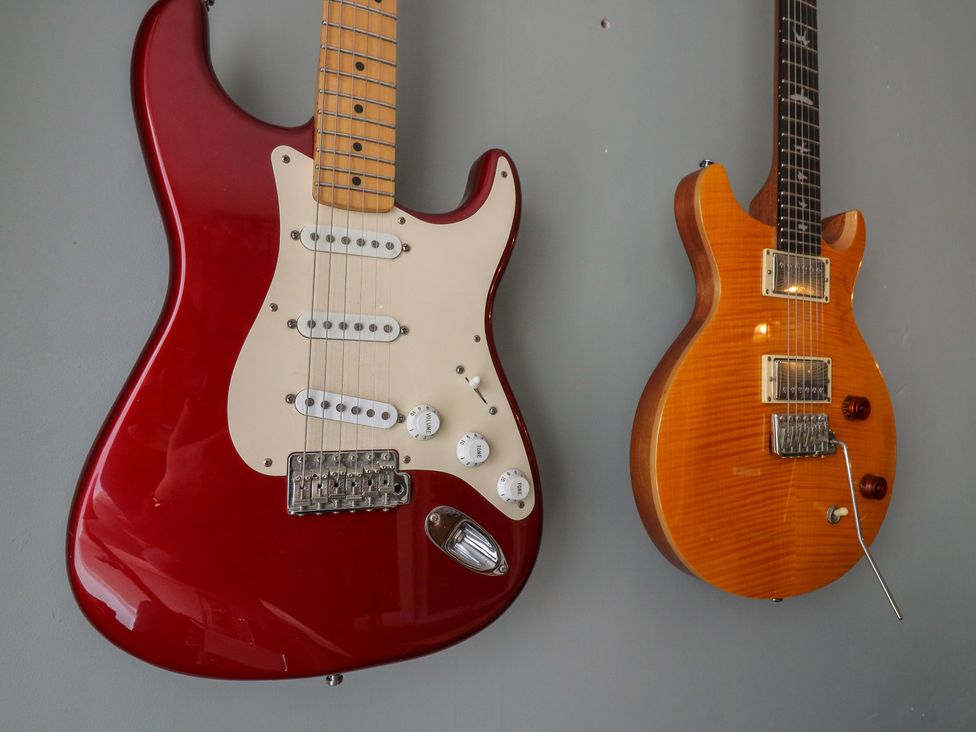 Two electric guitars hanging on a wall at Denmark House, Chatham, Kent