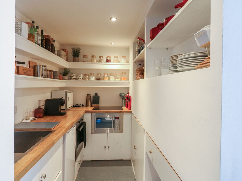 A kitchen with shelves and appliances at Denmark House in Chatham, Kent