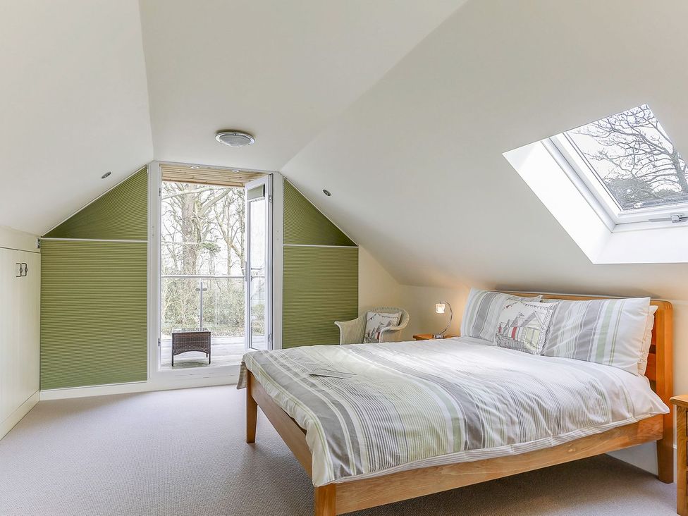 A bedroom with a bed and window at Poppyfields Stable Redruth