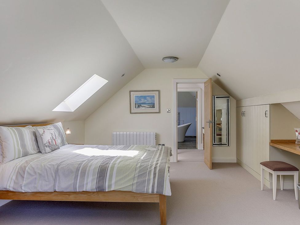 A bedroom with a bed and radiator at Poppyfields Stable in Redruth