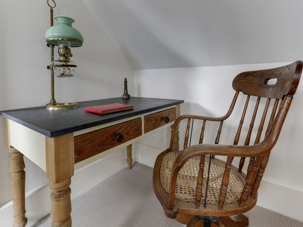 An office with a desk and a wooden chair at Poppyfields Stable in Redruth