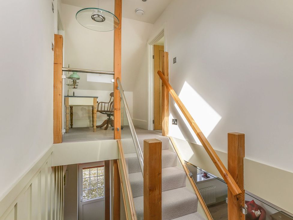 A hallway with a staircase and table at Poppyfields Stable in Redruth