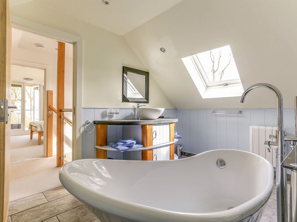 A bathroom with a bathtub and vanity at Poppyfields Stable Redruth