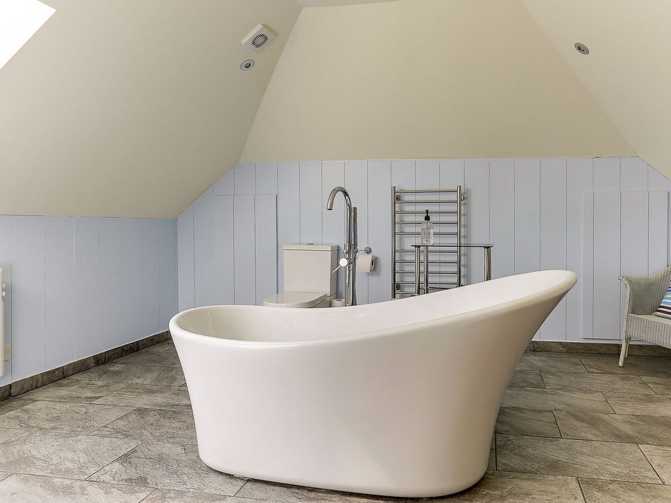 A bathroom featuring a bathtub and a toilet at Poppyfields Stable Redruth