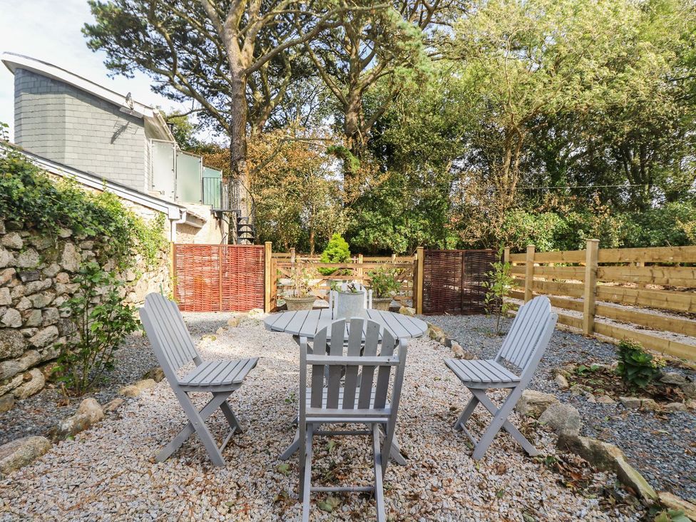 A garden with a table and chairs at Poppyfields Stable in Redruth