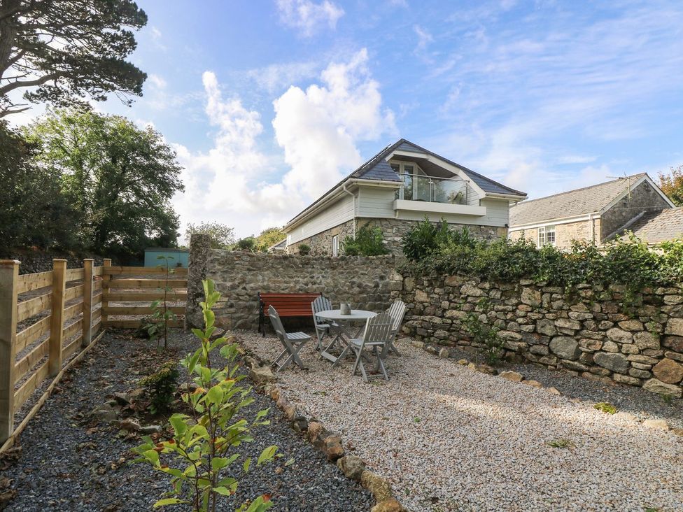 A garden with a table and chairs at Poppyfields Stable in Redruth