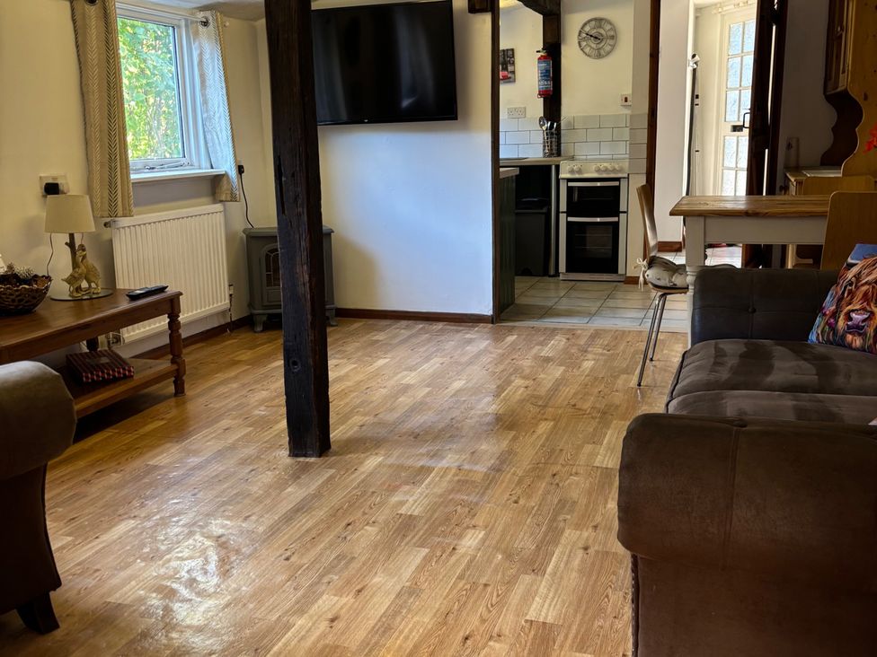 A living room with a television and kitchen visible at 2 Bed Barn in Barroway Drove near Downham Market