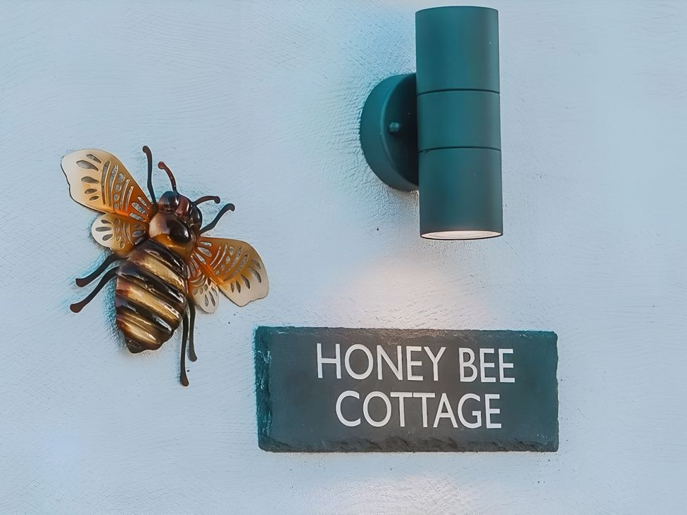 A bee decoration and sign at Honey Bee Cottage in Welshpool