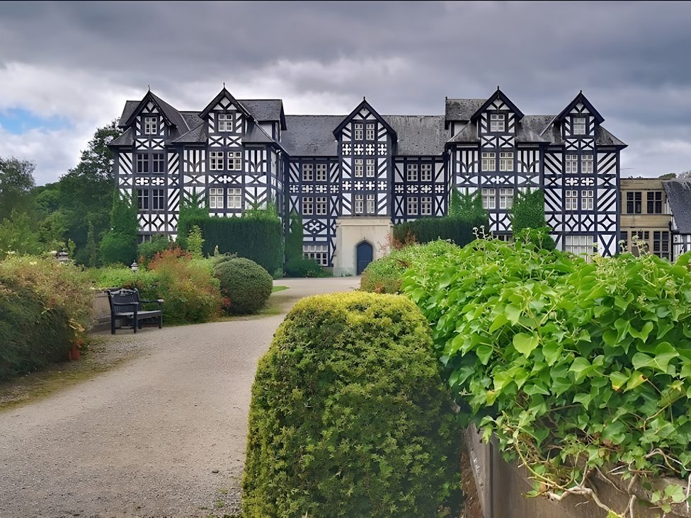 A building with a pathway and gardens at Honey Bee Cottage in Welshpool