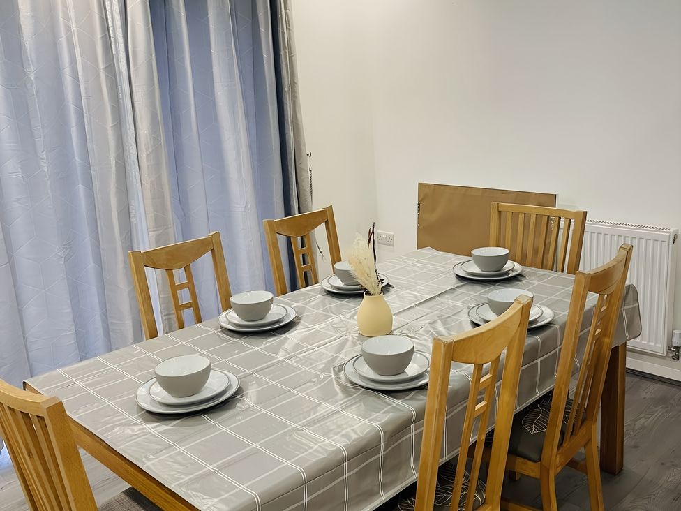 A dining room with a table set for six at Citrine Suite in Stoke-on-Trent